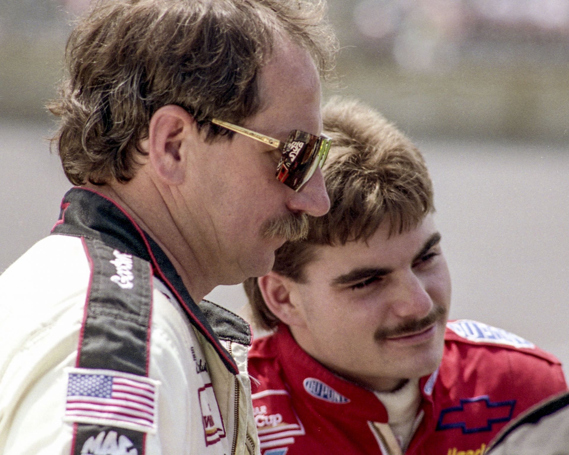 DAYTONA BEACH, FL - JULY 1993:  Jeff Gordon (L) in the rookie year of his NASCAR career, talks with Dale Earnhardt Sr. at Daytona International Speedway circa July 1993 in Daytona Beach, Florida.  (Photo by Brian Cleary/Getty Images) - Source: Getty